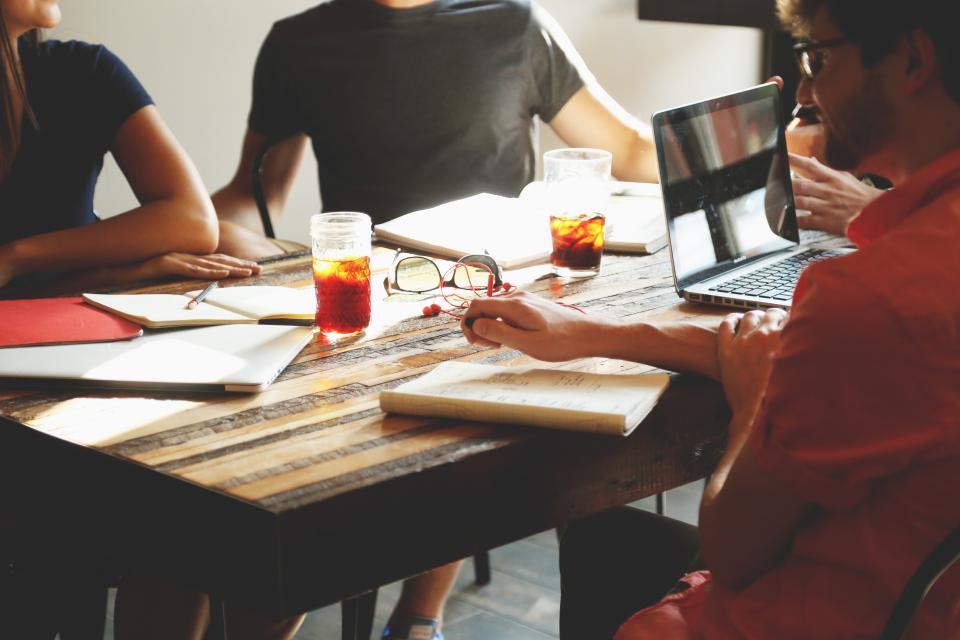 A small group working together around a laptop